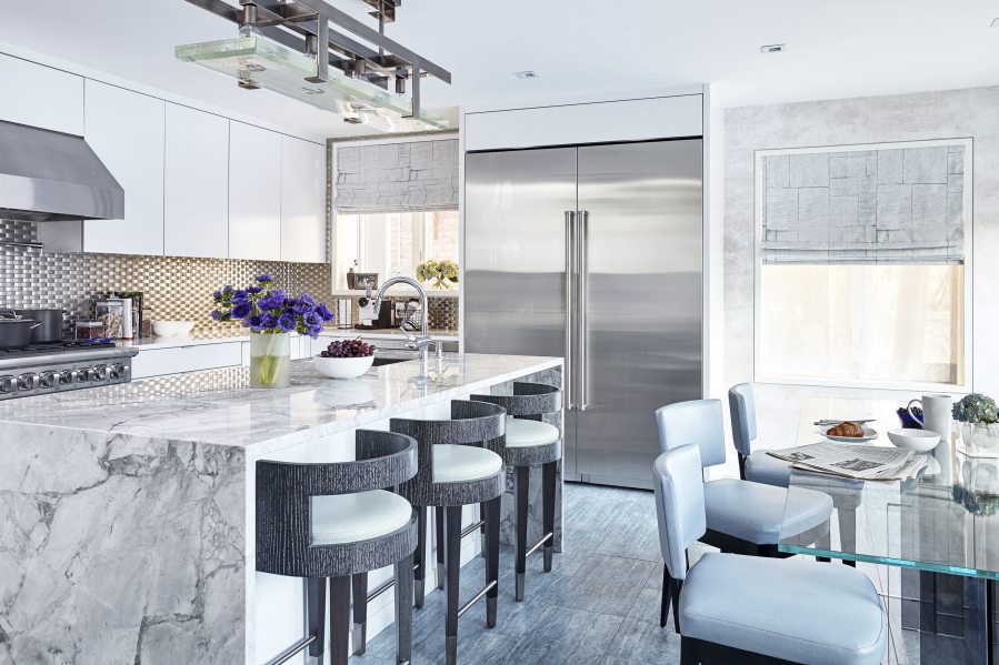 This undated photo provided by interior designer Jenny Kirschner shows a kitchen designed by Kirschner. Although kitchen backsplashes are often made of porcelain or ceramic tile, Kirschner used stainless steel to give this open, airy kitchen a fresh, modern look.