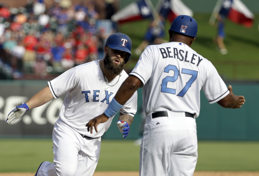 Texas Rangers' Mike Napoli, left, is congratulated by third base coach Tony Beasley (27) after hitting a two-run home run in the sixth inning of a baseball game against the Seattle Mariners, Saturday, June 17, 2017, in Arlington, Texas.