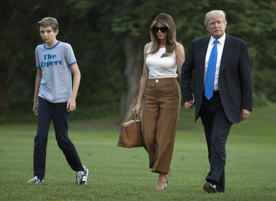 President Donald Trump, first lady Melania Trump, and their son and Barron Trump walk from Marine One across the South Lawn to the White House in Washington on June as they return from Bedminster, N.J.