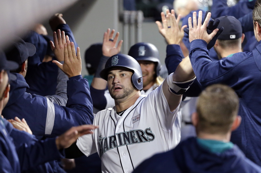 Seattle Mariners' Mike Zunino is congratulated by teammates in the dugout on his grand slam against the Tampa Bay Rays during the fifth inning of a baseball game Saturday, June 3, 2017, in Seattle.