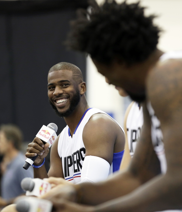 FILE - In this Sept. 26, 2016, file photo, Los Angeles Clippers' Chris Paul laughs as he, Blake Griffin and DeAndre Jordan, right, talk during the team's NBA basketball media day, in Playa Vista, Calif. The Houston Rockets have reached an agreement to trade for Los Angeles Clippers point guard Chris Paul according to a person familiar with the deal.