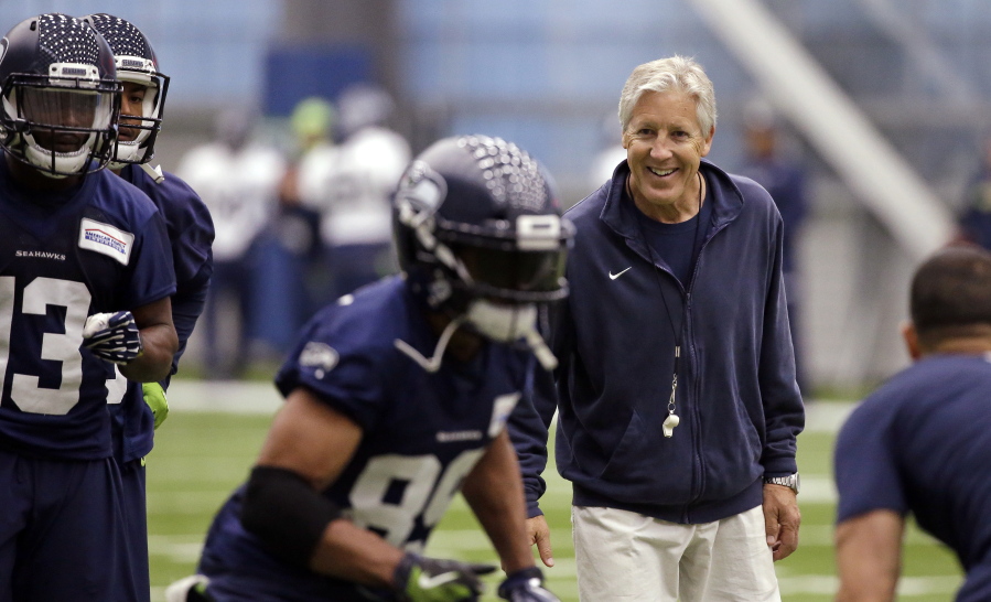 Seattle Seahawks head coach Pete Carroll, right, smiles as he watches Doug Baldwin run a drill during NFL football practice Thursday, June 15, 2017, in Renton, Wash.