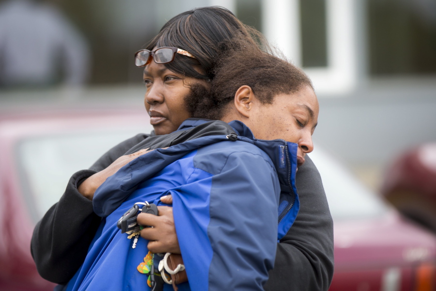 Monika Williams, front, the victim’s relative, is comforted Sunday in Seattle.