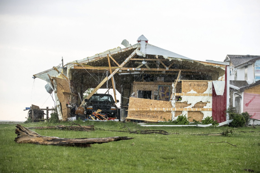 In this Wednesday, June 28, 2017 photo, a car sits in a garage, damaged after a tornado hit the property of Dee and Lynn Ossian in Farragut, Iowa.