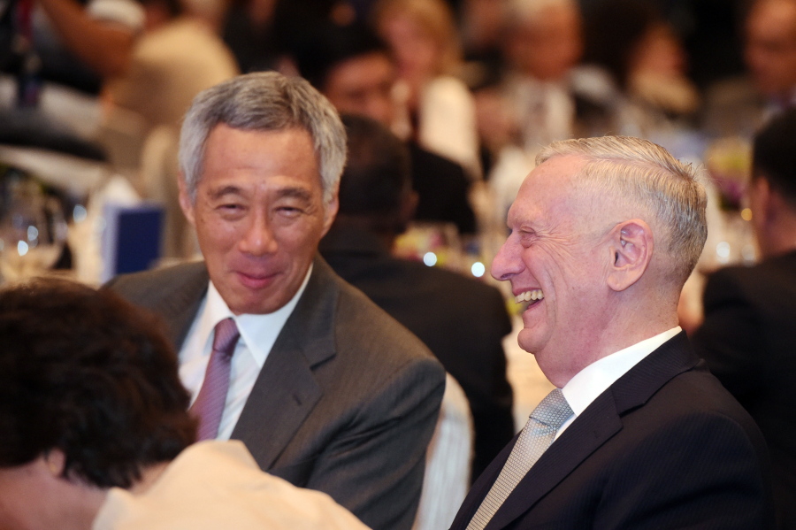 U.S. Defense Secretary Jim Mattis, right, sits with Singapore’s Prime Minister Lee Hsien Loong on Friday as they attend the opening dinner of the 16th International Institute for Strategic Studies Shangri-la Dialogue Asia Security Summit in Singapore.