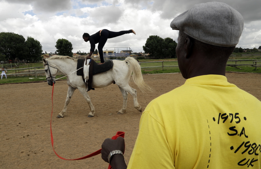 Enos Mafokate watches Naledi Mokoena, 13, during equestrian vaulting practice in February at the Soweto Equestrian Centre in Johannesburg, South Africa.