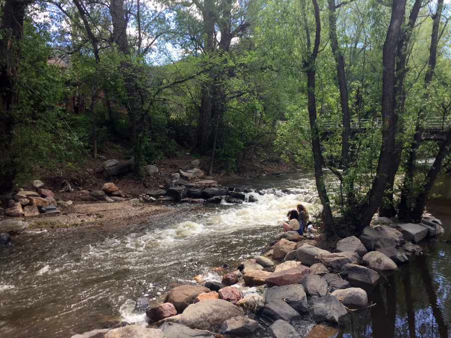 People relax along Boulder Creek in Boulder, Colo. The 8-mile Boulder Creek Path alongside the waterway is a scenic trail where you can stroll, bike or just sit for a few peaceful moments. (AP Photo/Beth J.