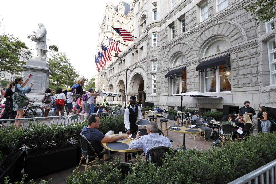 Protesters yell at patrons at the outdoor seating area at the Trump International Hotel, Wednesday, June 28, 2017, in Washington. President Donald Trump is attending a fundraiser at the hotel.