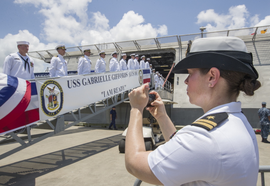 Lt. Miranda Williams of the U.S. Navy photographs sailors as they board the newly commissioned USS Gabrielle Giffords during a commissioning ceremony in Galveston, Texas on Saturday, June 10, 2017. The new warship named after former Arizona congresswoman who was wounded during a deadly 2011 shooting, has been put into active service following the ceremony.