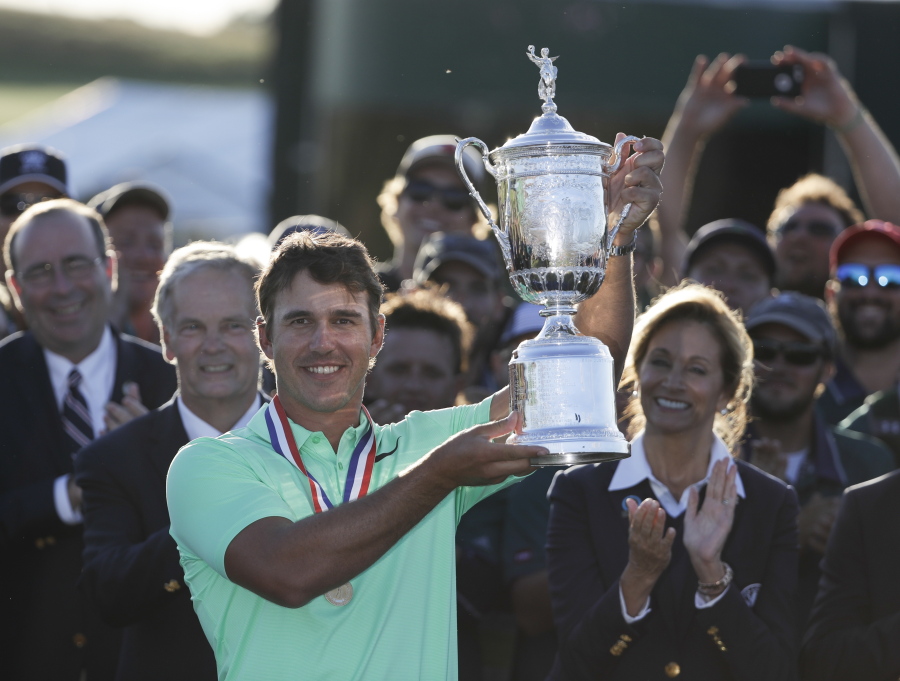 Brooks Koepka holds up the winning trophy after the U.S. Open golf tournament Sunday, June 18, 2017, at Erin Hills in Erin, Wis.