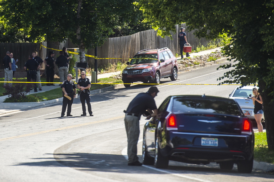 Police officers investigate the scene of a shooting in Sandy, Utah, on Tuesday. Utah police say the shooter in a suburban Salt Lake City neighborhood is among several people who died in the incident and two others injured were children. The shooting took place on a neighborhood street in the suburb of Sandy, about 20 miles southeast of Salt Lake City.