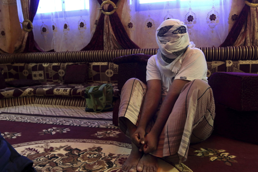 A former detainee shows how he was kept in handcuffs and leg shackles while held in a secret prison at Riyan airport in the Yemeni city of Mukalla in this May 11, 2017 photo. He covered his face for fear of being detained again. He and other former detainees say abuses are widespread in a network of secret prisons run by the United Arab Emirates and its Yemeni allies, into which hundreds detained in the hunt for al-Qaida militants have disappeared.