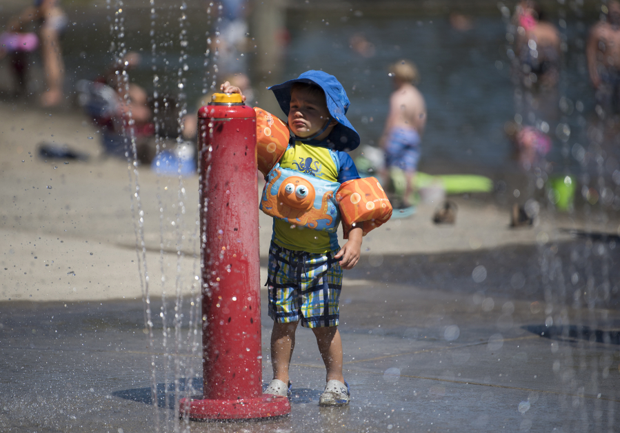 Carter Olsen, 2, of Vancouver plays in the water features at Klineline Pond in Salmon Creek on Monday afternoon. Temperatures are expected to reach near-record highs by midweek.