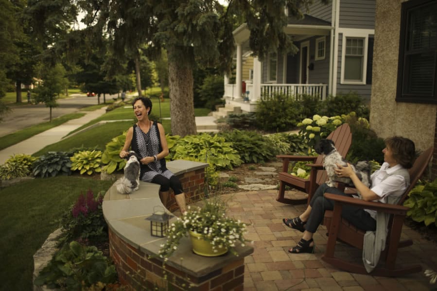 Bobbi Deeney, left, and Beth Gunderson with their dogs, Oliver and Nelson, on the patio in front of Deeney’s house in the Minikahda Vista neighborhood of St. Louis Park, Minn.