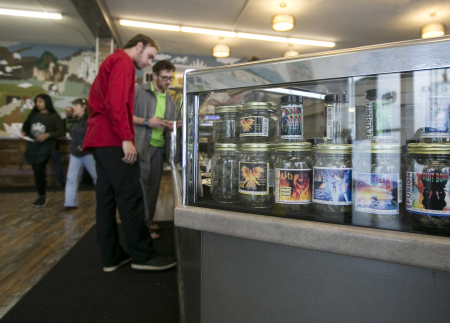 Customers peruse products in a case at Main Street Marijuana in downtown Vancouver. The city’s portion of the marijuana taxes will go toward law enforcement.
