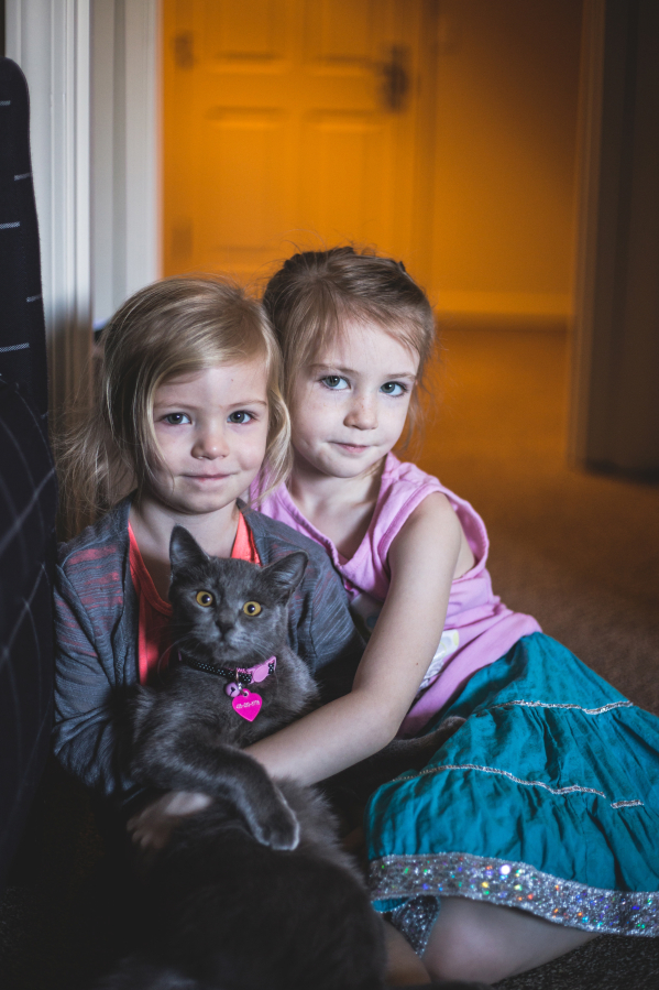 Molly and Elinor Egan hold their cat, Cleo.