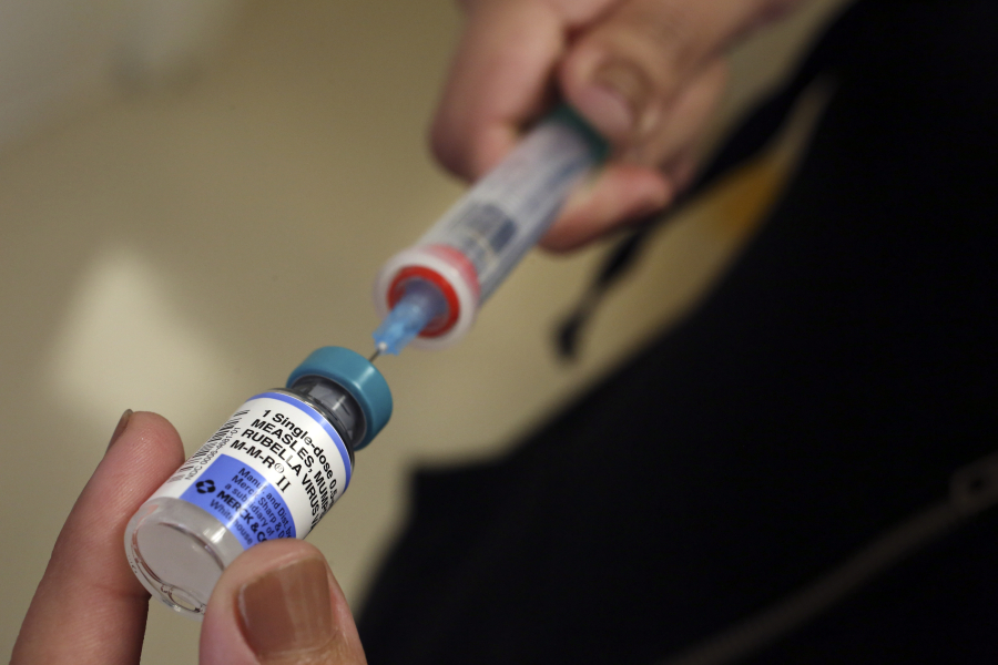 A vial containing the MMR vaccine is loaded into a syringe before being given to a baby at the Medical Arts Pediatric Med Group in Los Angeles.
