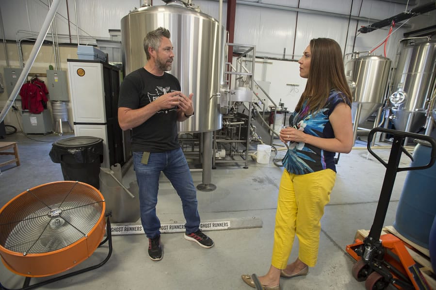 Jeff Seibel, co-owner of Ghost Runners Brewery, left, chats with U.S. Rep. Jaime Herrera Beutler at Ghost Runners Brewery on Thursday. A bill co-sponsored by the Camas republican would cut federal excise taxes paid by the breweries.