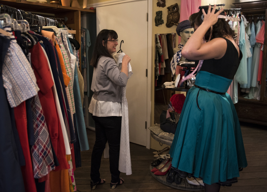 Seamstress Amy Anthonson, right, helps customer Melissa Kershner, left, both of Vancouver, at Most Everything Vintage in downtown Vancouver. In-person service like tailoring can be a store’s defense against online shopping, said owner Alisa Tetreault.