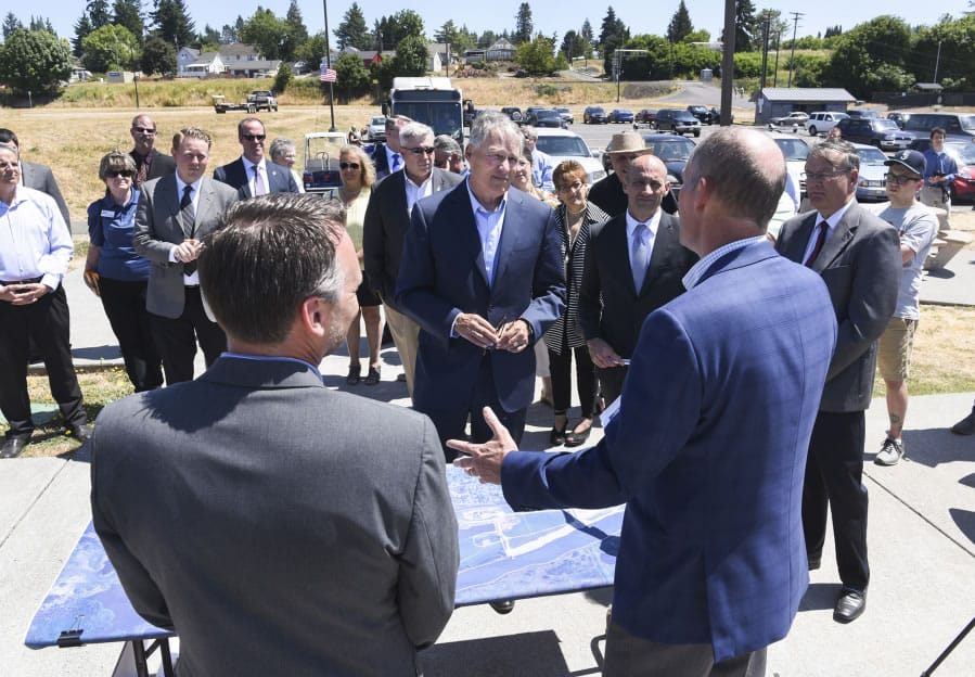 Gov. Jay Inslee, center, listens to Port of Ridgefield CEO Brent Grening, right, discuss the city, port and state joint effort to clean up the Ridgefield waterfront, which is ready for development after a $90 million clean-up effort. Inslee was in Ridgefield on Tuesday to tour the city.