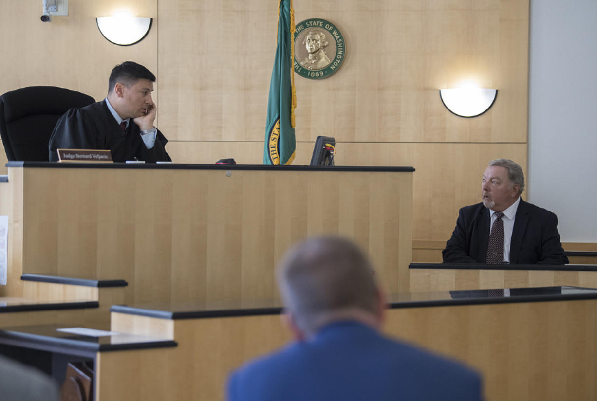 Judge Bernard Veljacic, left, talks with John Jones, a contract security company manager, as he testifies in an evidentiary hearing in a public records lawsuit on Monday morning. Veljacic ruled in favor of releasing footage from jail surveillance cameras that captured the incident that led to the 2015 death of Mycheal Lynch, an inmate at the jail.