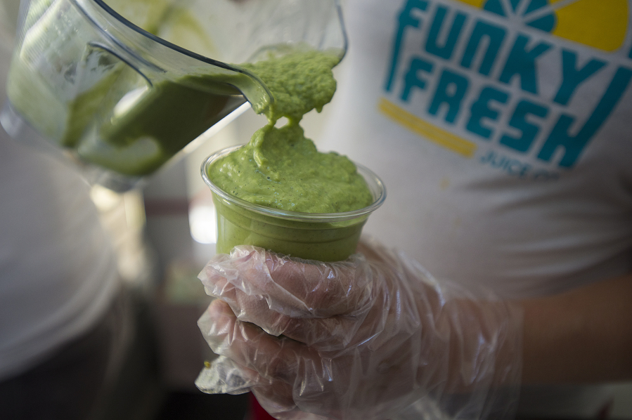 Mira Alexander, one of the co-owners of Funky Fresh Juice Co., pours a Jungle Boogie Smoothie for a customer while parked across from the Clark County Public Service Center. Funky Fresh started this summer and hopes to have a grand opening in mid-August.