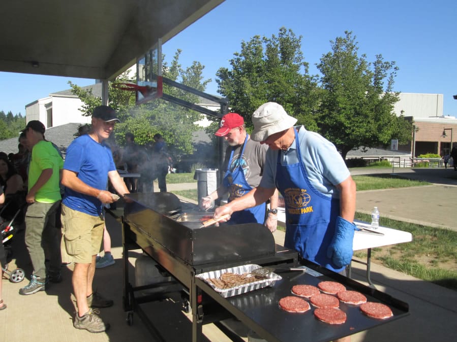 Five Corners: Cascade Park Kiwanis members, from left, Steve Savage, Clyde Holloway and John Neumann grill burgers and hot dogs for the annual foster children’s barbecue, hosted by the Kiwanis and Department of Social and Health Services.