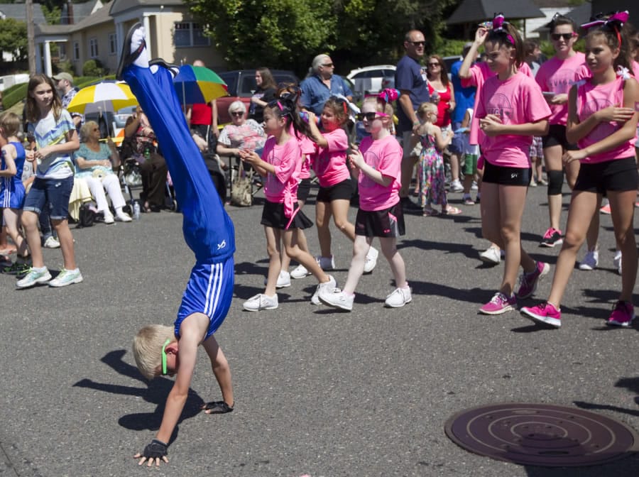 A gymnast walks on his hands as he takes part in the 2014 Camas Days Parade.