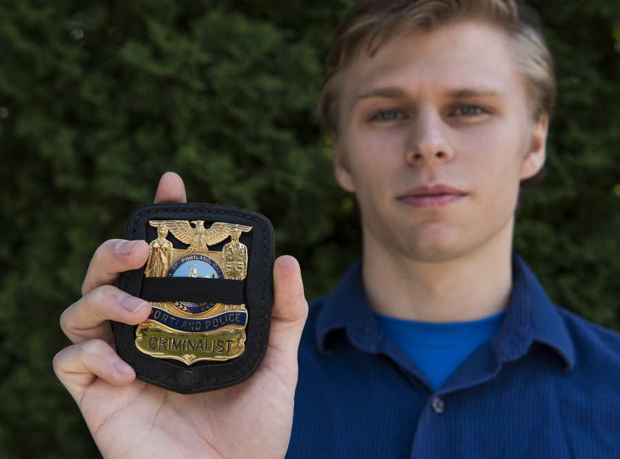 Union High School graduate Jake Cushman of Vancouver holds a replica of a badge that belonged to his father, Adam Cushman. When his father died in 2010, Jake Cushman and his brother were both given a replica of the badge that includes a black strap that commemorates fallen officers. Jake Cushman hopes to follow in his father’s footsteps by becoming a criminalist for the Portland Police Bureau.