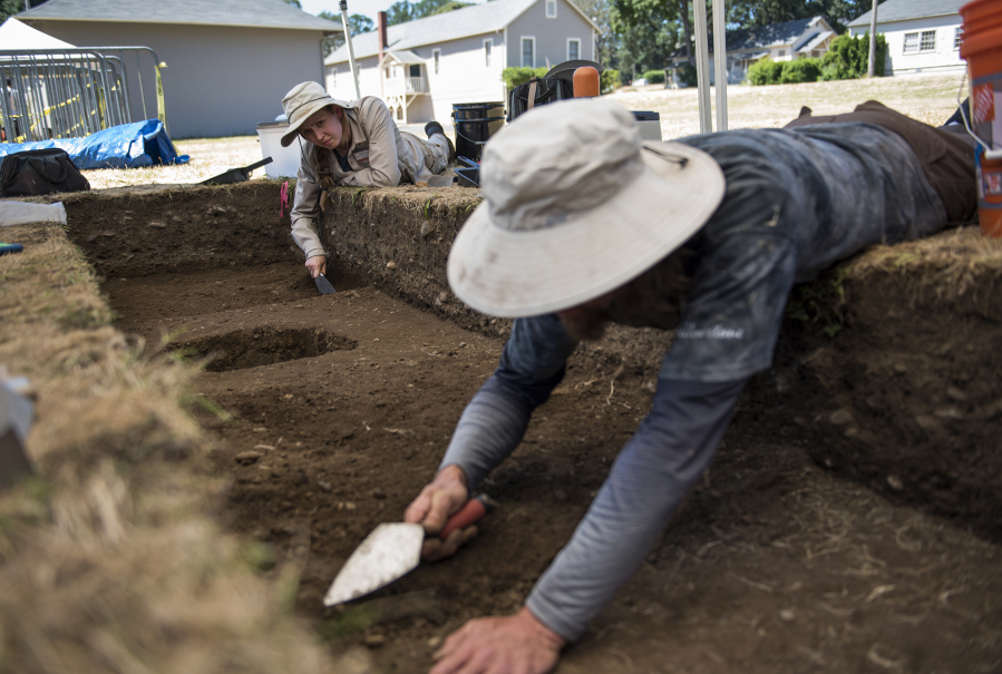 Co-field director Katie Wynia of Portland, from left, and Portland State University graduate Jesse Nelson of Portland trowel a dig site Friday during the annual archaeological summer field school on the south side of Vancouver Barracks in the Fort Vancouver National Historic Site.