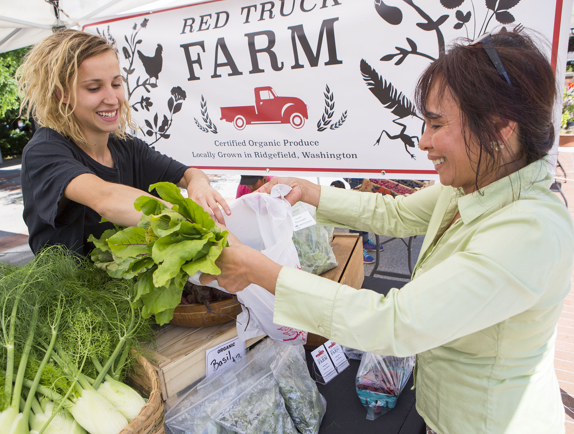Rachel Elston, left, of Red Truck Farm helps Clark County office assistant II Percy Flora purchases fresh produce at Franklin Street Farmers Market on Wednesday morning, July 12, 2017.