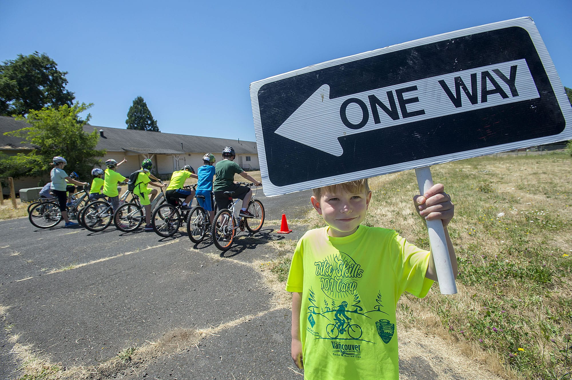 Julian Charbonneau, 8, helps with the signage as cyclists prepare to take off from the starting line during Bike Skills 101 Camp at Fort Vancouver National Historic Site on Tuesday afternoon, July 11, 2017.