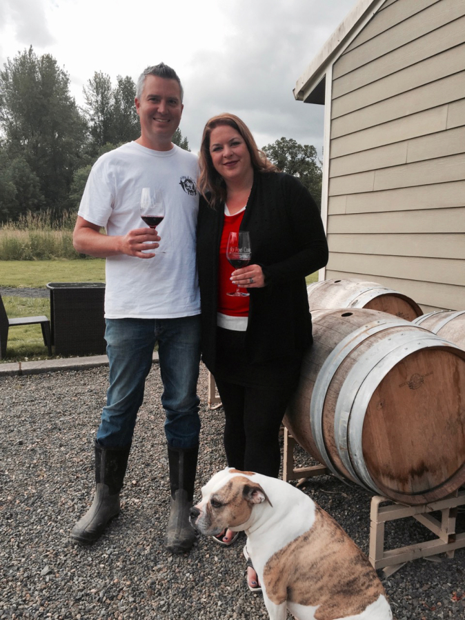Wes and Michelle Parker of Koi Pond Cellars sip wine with their winery dog Jameson at their new tasting room and event space in Ridgefield.