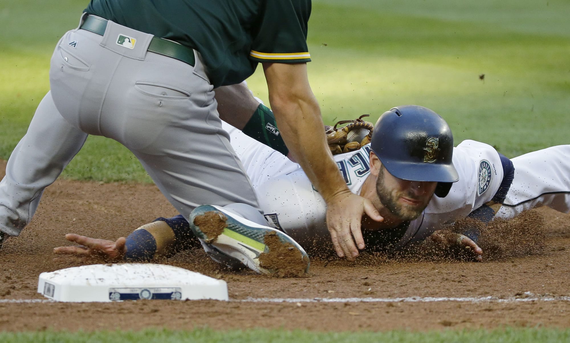 Seattle Mariners' Mitch Haniger, right, is tagged out at third base by Oakland Athletics third baseman Matt Chapman during the third inning of a baseball game, Thursday, July 6, 2017, in Seattle. Haniger was trying to advance after a fly ball hit by Jarrod Dyson was caught by Oakland Athletics center fielder Jaycob Brugman. (AP Photo/Ted S.