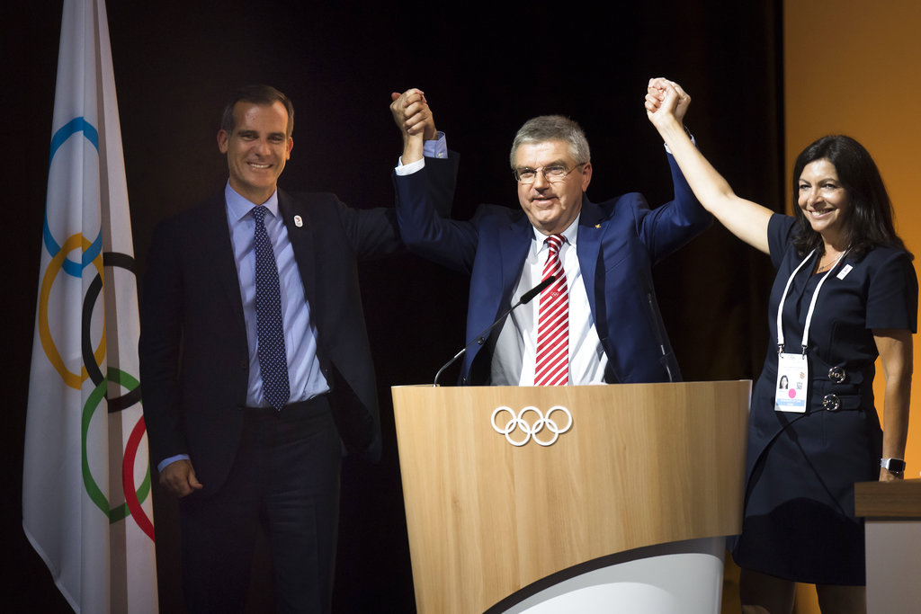Eric Garcetti, Mayor of Los Angeles, left, International Olympic Committee, IOC, President Thomas Bach, from Germany, center, and Anne Hidalgo, Mayor of Paris, right, pose together during the International Olympic Committee (IOC) Extraordinary Session, at the SwissTech Convention Centre, in Lausanne, Switzerland, Tuesday, July 11, 2017. The IOC has decided it can pick both Los Angeles and Paris as Olympic host cities in September when the 2024 and 2028 Summer Games rights should be awarded simultaneously.