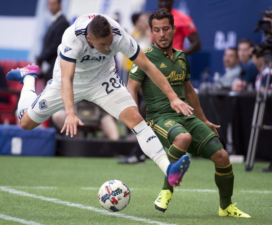 Vancouver Whitecaps defender Jake Nerwinski (28) vies for control of the ball with Portland Timbers midfielder Sebastian Blanco, right, during the first half of MLS soccer game action in Vancouver, British Columbia, Sunday, July, 23, 2017.