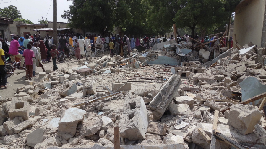 People gather at the site of a suicide bomb attack that killed several people Monday in Maiduguri, Nigeria. The attack was blamed on the Boko Haram extremist group.