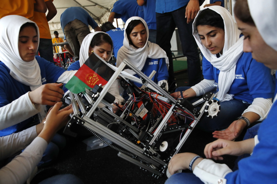 Lida Azizi, right, and other members of the Afghanistan team make a repair to their robot after their first round competing in the FIRST Global Robotics Challenge, Monday in Washington. The challenge is an international robotics event with teams from over 100 countries.