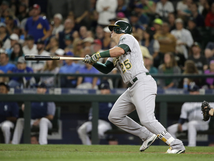 Oakland Athletics' Ryon Healy watches an RBI double against the Seattle Mariners during the ninth inning of a baseball game, Saturday, July 8, 2017, in Seattle.