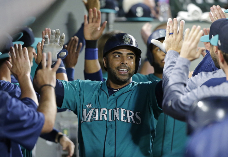 Seattle Mariners' Nelson Cruz is greeted in the dugout after he hit a three-run home run during the eighth inning of the team's baseball game against the Oakland Athletics, Friday, July 7, 2017, in Seattle. (AP Photo/Ted S.