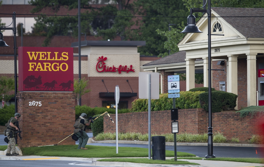 Police officers move toward a Wells Fargo Bank on Friday in Marietta, Ga., after a man who claimed to have a bomb barricaded himself inside the bank.