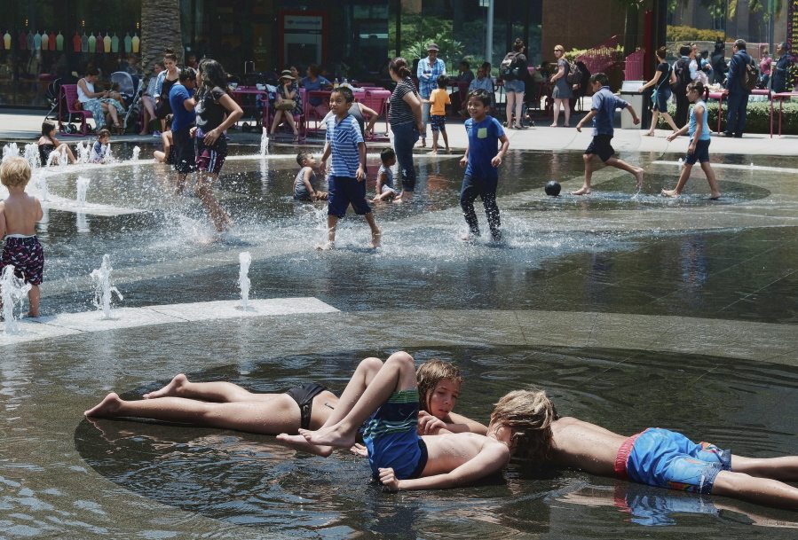 Children out of school for the summer take advantage of the Grand Park fountain in downtown Los Angeles on Wednesday, July 5, 2017. Forecasters say a new heat wave is setting in across the interior of Southern California, and the southern Sierra Nevada is facing a period of elevated fire danger. The National Weather Service says the heat is coming from high pressure building over the desert Southwest that will expand westward.
