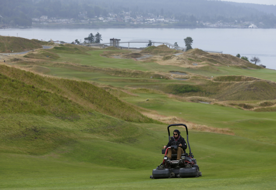 Greenskeeper Slater Heath mows near the 12th green at Chambers Bay. Ted S.