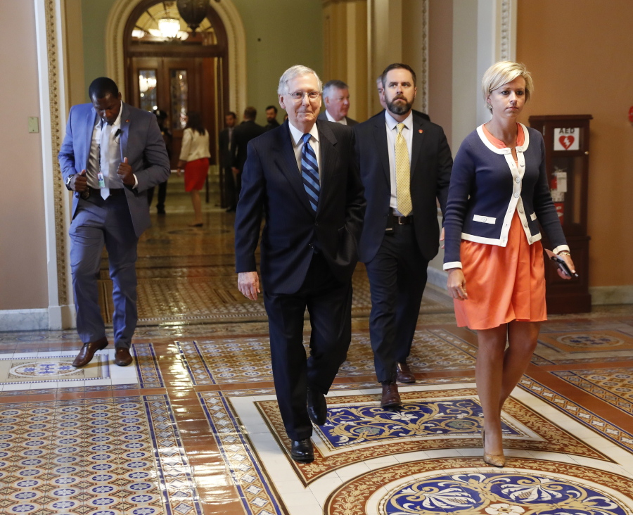 Senate Majority Leader Mitch McConnell of Ky., with his director of operations Stefanie Hagar Muchow, right, walks to his office on Capitol Hill in Washington, Tuesday, July 11, 2017.