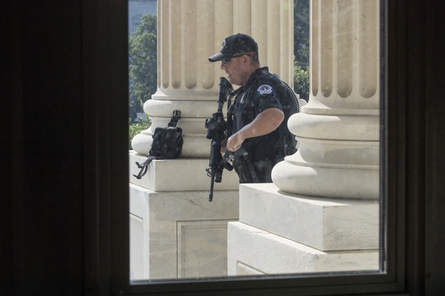 FILE - In this June 14, 2017 file photo, a Capitol Hill Police officer stands his post at the entrance to the House of Representatives on Capitol Hill in Washington. U.S. Capitol Police have investigated more threats to members of Congress in the first six months of the year than in all of 2016, says the chief law enforcement official for the House, as Majority Whip Steve Scalise remains hospitalized after a gunman opened fire at a baseball practice nearly a month ago. (AP Photo/J.