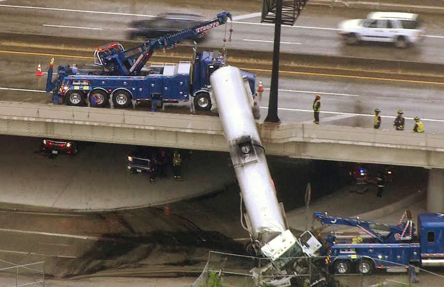 Amergency responders work to lower a tanker truck to the ground after it crashed off an Interstate 44 overpass in downtown St. Louis, Thursday, July 27, 2017.