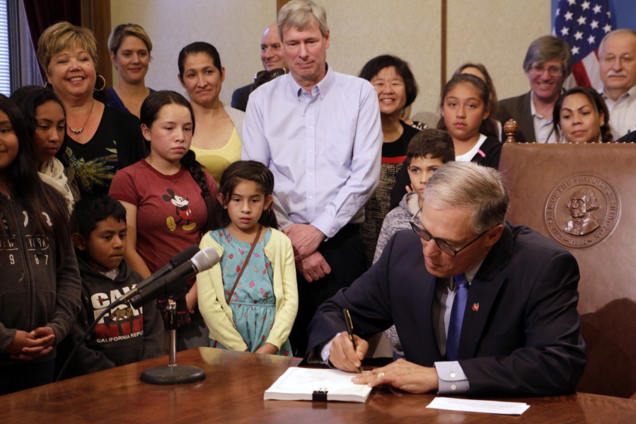 Washington Gov. Jay Inslee signs into law a measure that seeks to bring the state into compliance with a court mandate to increase state dollars to basic education Thursday, July 6, 2017, in Olympia. Washington has been in contempt of court for lack of progress on satisfying a 2012 state Supreme Court ruling that found that school funding was not adequate.