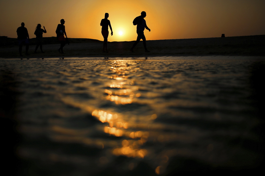 FILE - In this file picture taken Thursday, Aug. 20, 2015, tourists walk on the Giftun Island beach as the sun sets over the Red Sea in Hurghada, Egypt. Egypt’s Interior Ministry said Friday, July 14, 2017 six foreign tourists, of various nationalities, were wounded when a man attacked them with a knife in the Red Sea resort of Hurghada. The ministry says the assailant was arrested immediately after the stabbings on Friday. It says the initial investigation shows the man sneaked into a hotel by swimming from a nearby beach and stabbed the tourists.