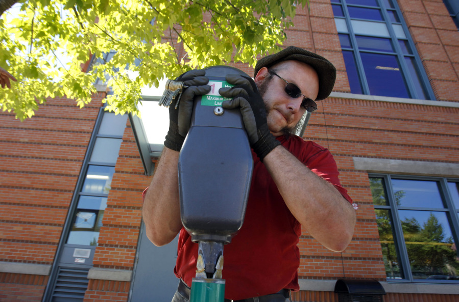 Jon Conlon removes parking meters in downtown Eugene, Ore., in September 2010. Free parking could soon be a thing of the past in downtown Eugene.
