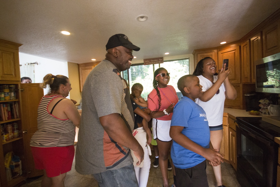 In this Thursday, July 6, 2017 photo, the Randle family looks around their kitchen to see that there are no more broken cabinets after friends and family renovated their home in Poulsbo, Wash.